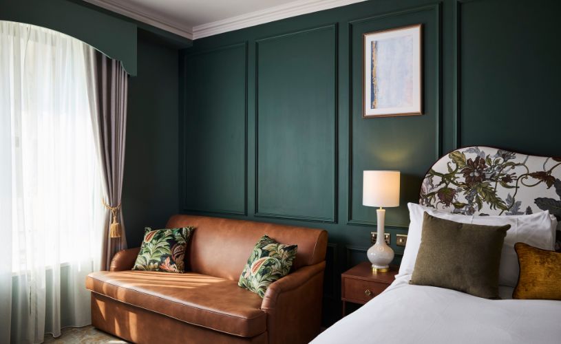 Bedroom at The Francis Hotel with green walls and large bed